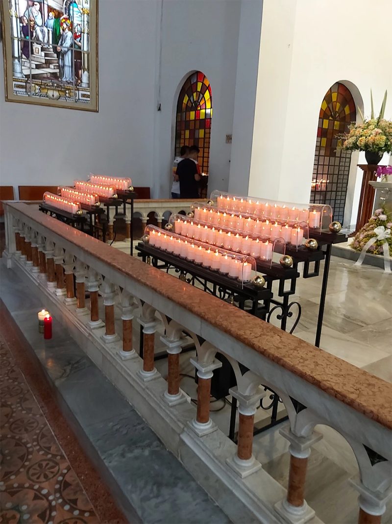 Lampararios de hierro forjado de 50 velas sobre el barandal del templo